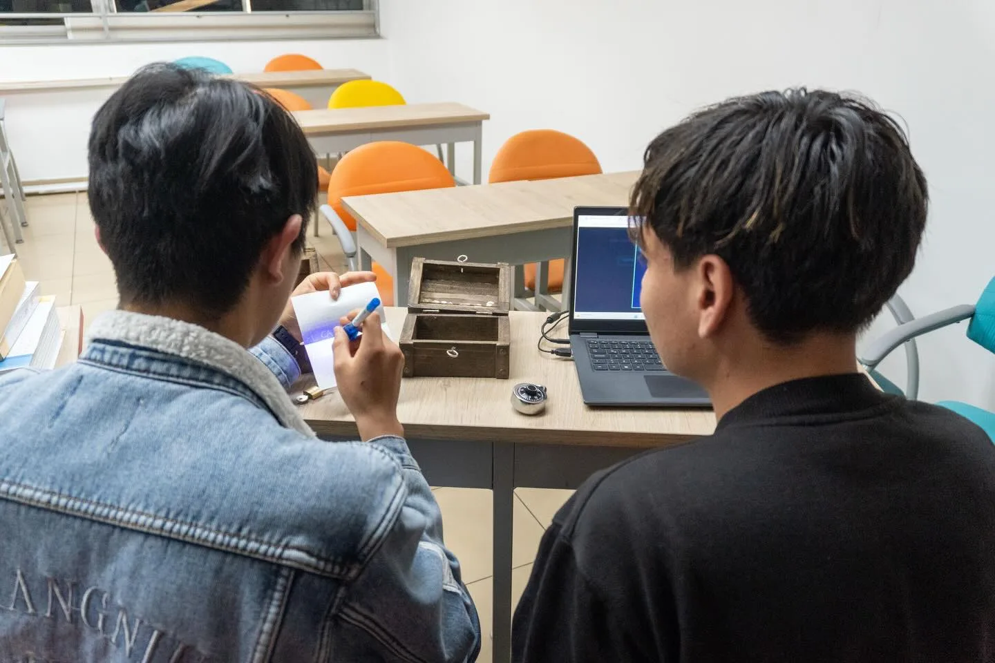 Estudiantes de KrakeDev aprendiendo programación con una laptop en clase
